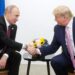 Putin and Trump shake hands, sitting side by side in a file photo.